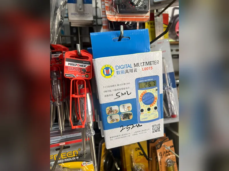 Digital multimeter C-Mart dan tespen Maxpower tergantung di rak
