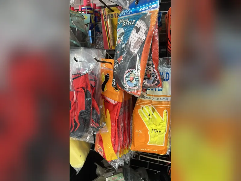 Sarung tangan latex dan masker kerja tergantung di rak toko