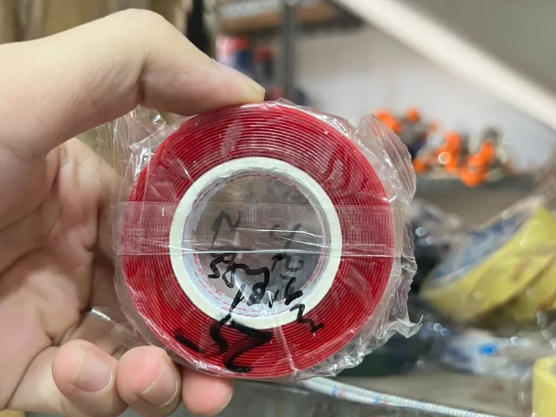 Roll double tape foam merah dipegang di tangan